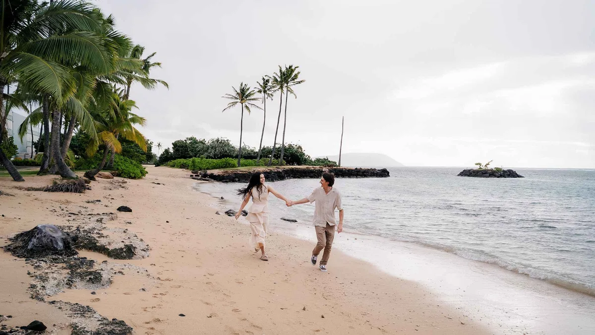 Photographer directing a family on an Oahu beach during a private vacation photoshoot in Hawaii